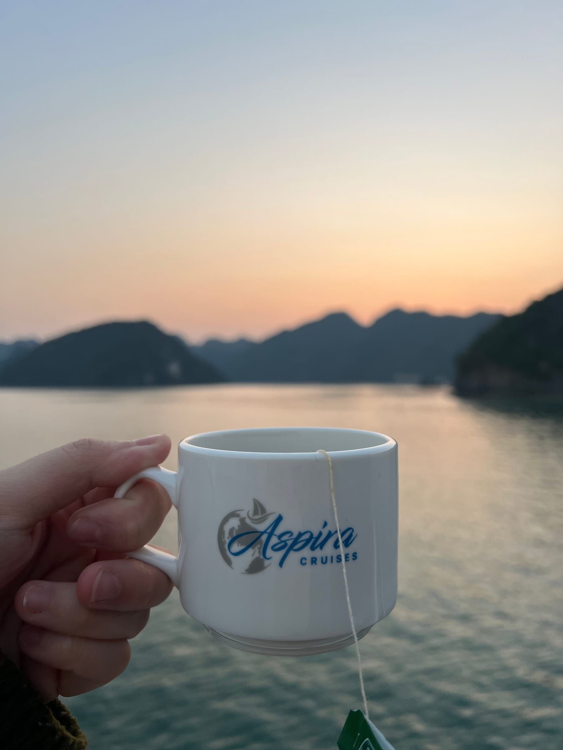 Morning coffee in an Aspira Cruises cup as the sun comes up over the bay