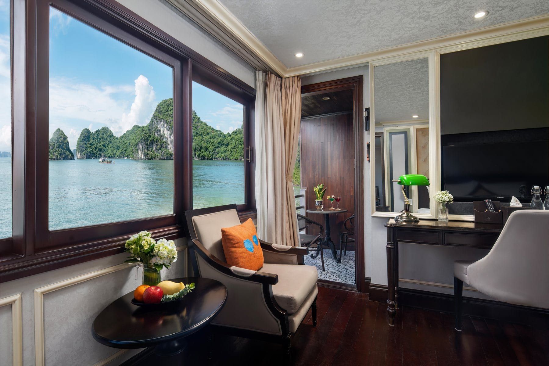 An Elegance Balcony cabin, cream panelling and a seating corner by the window
