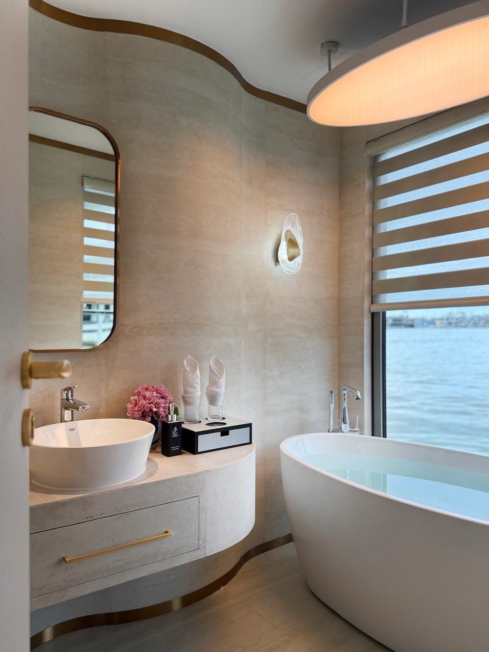 A freestanding bathtub beside the window in an Athena Premium bathroom