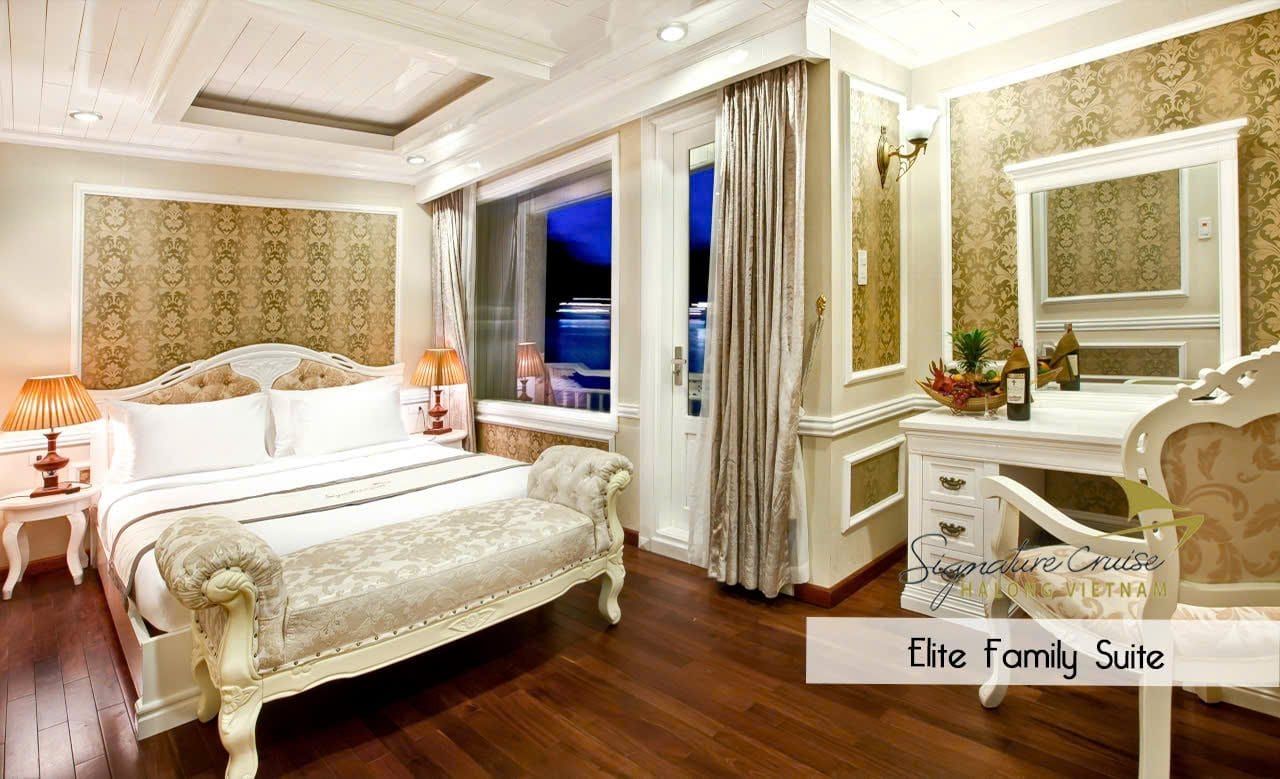 The Elite Family Suite, a carved bed frame and bay windows down one side