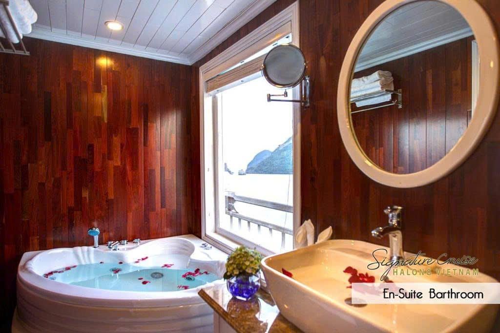 The en-suite bathroom of the Elite Family Suite, a corner jacuzzi bathtub beside the window