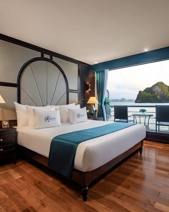 An Aspira cabin in teal and timber, windows opening onto the bay